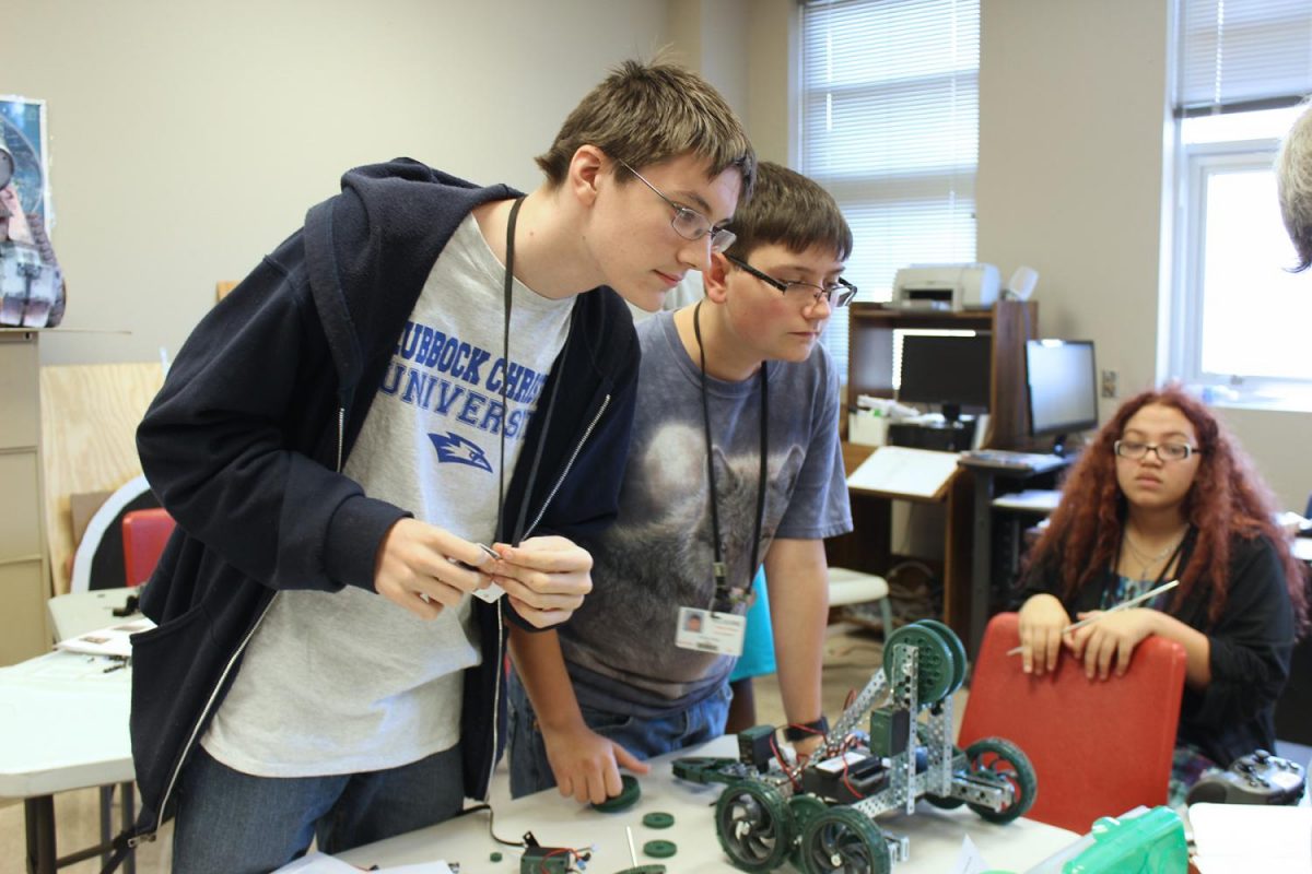 Sophomores Kendall Sloan, Justiss Ross, and Shelby Woods look over their robot.