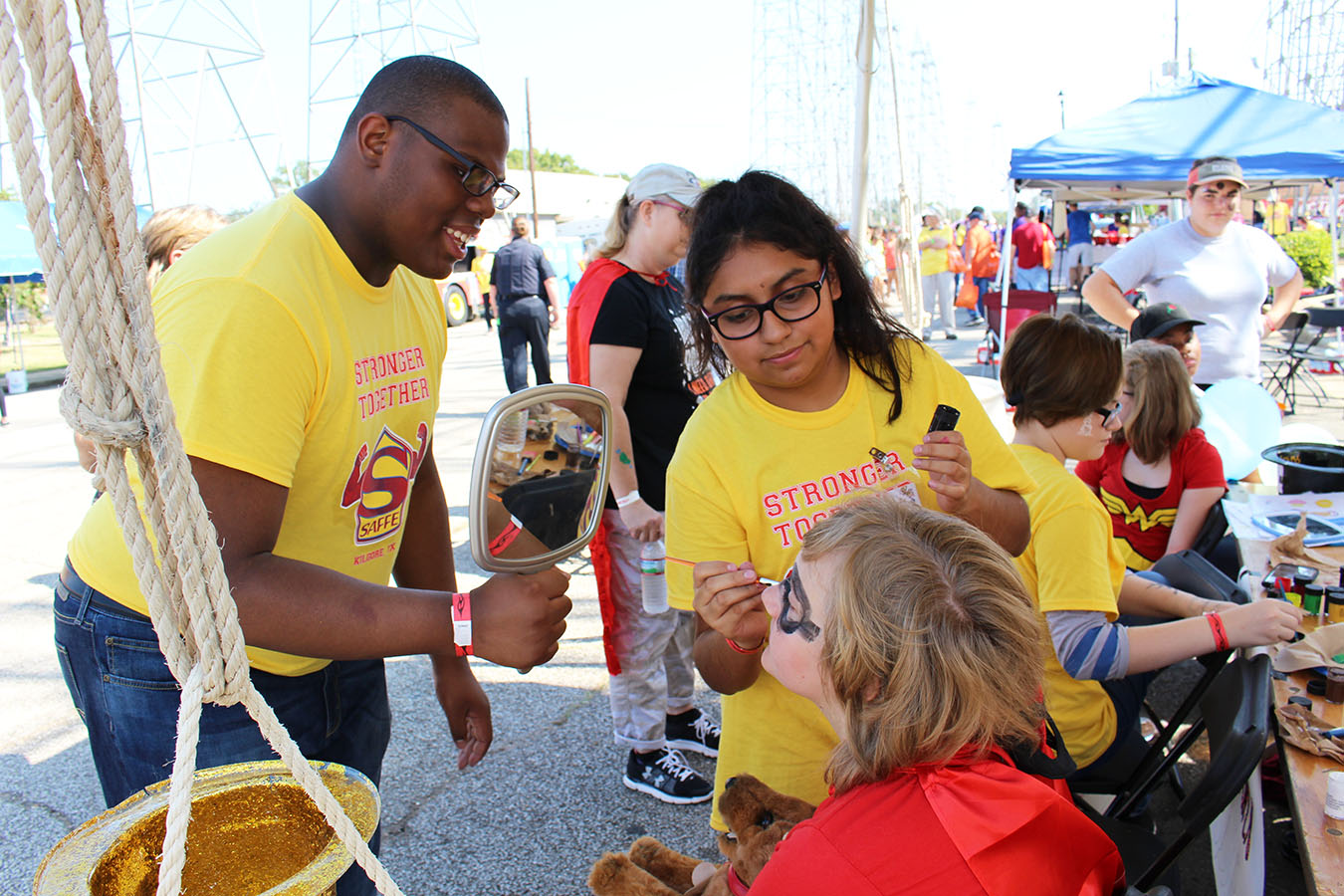 Senior Quavion Hollins and junior Vanessa Zarazua tend to a young customer as sophomore Jordan Callaway cleans brushes.