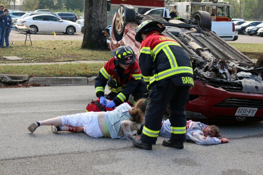 First responders approach mock victims and seniors Bailey Green and Elijah Williams.