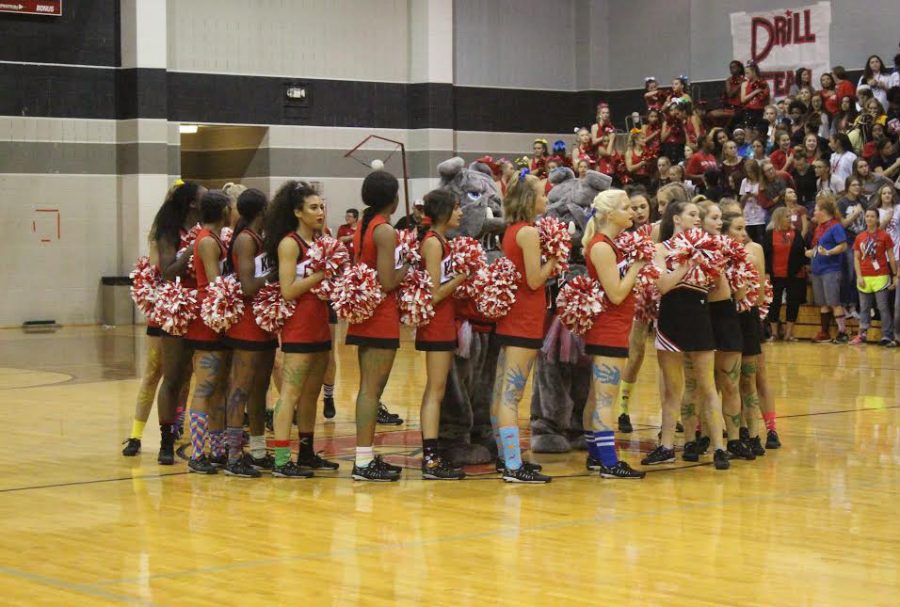 Tacky cheerleaders stand together for the national anthem at the pep rally. 