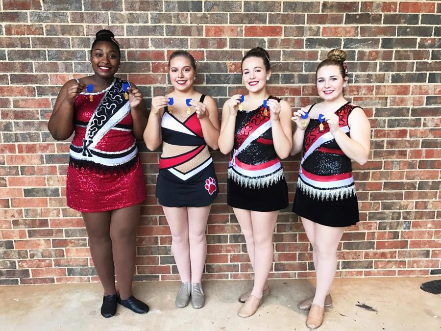 Twirlers hold their medals they received for making ones on their routines.  Twirlers are juniors Diamond Smith, Jordan Ware, sophomore Olivia Arp, and junior Hannah Howell.