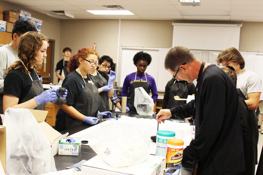 Coach Deans forensic science class watches and learns how to properly dust for fingerprints. 