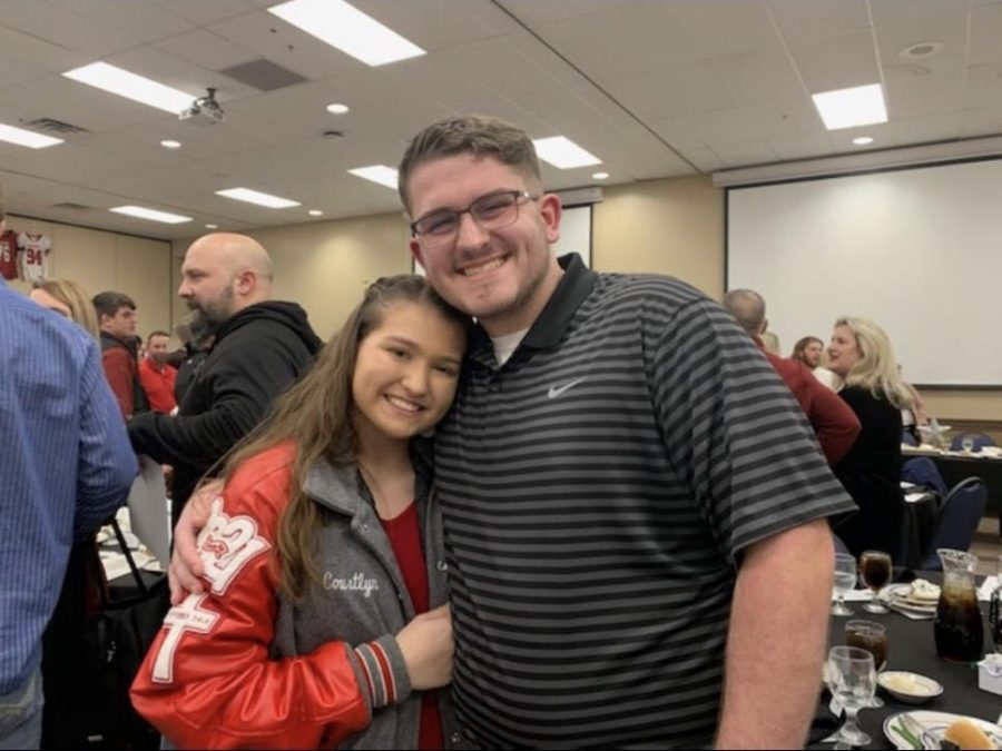 Junior Courtlyn Brown and senior Scott Silvey pose as boyfriend and girlfriend at football banquet. 