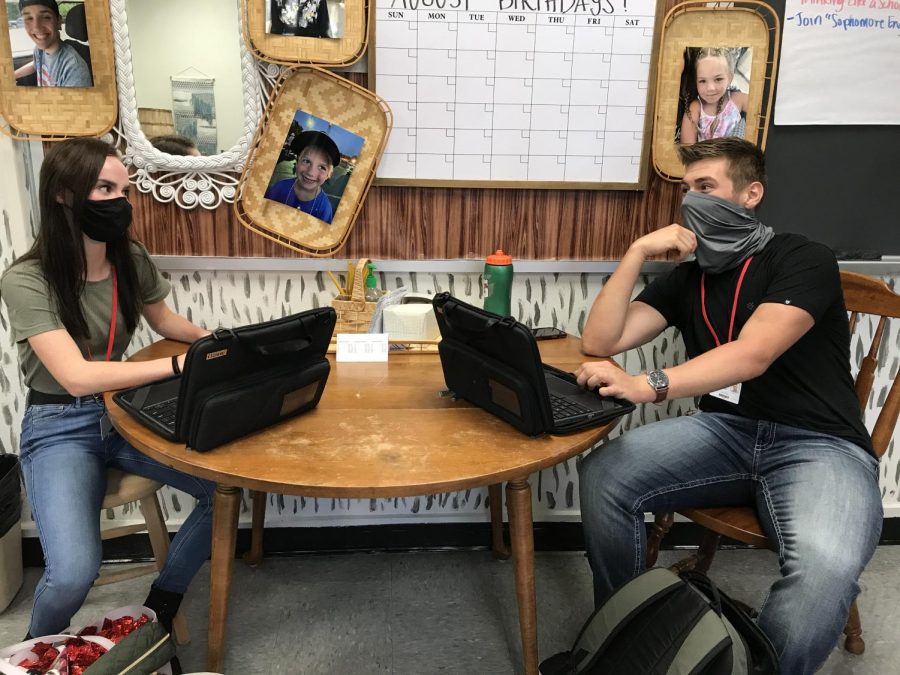 Juniors Karlee Menges and Jared Rich demonstrate the newest additions to the year. These additions are the school provided chromebooks and wearing a mask. Its been strange getting used to this new version of school, but Im glad to be back, Rich said. 