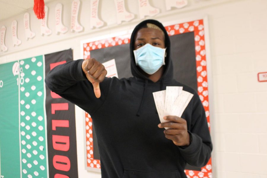Senior Donovan Adkins shows his disappointment while holding concert tickets to a show that was cancelled. 