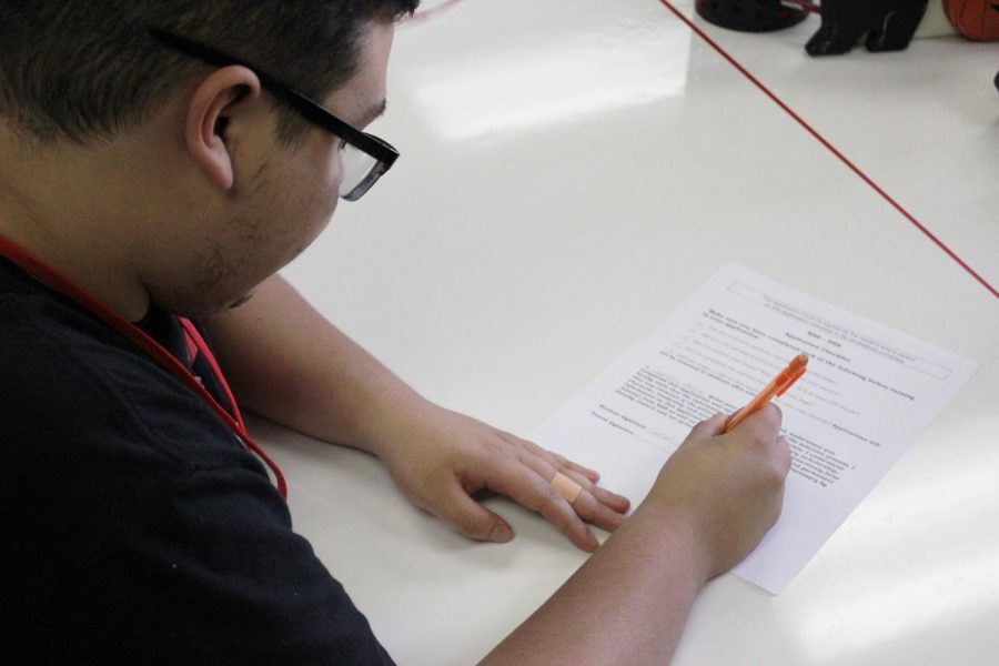 Junior Carlos Ortiz completes his NHS application.