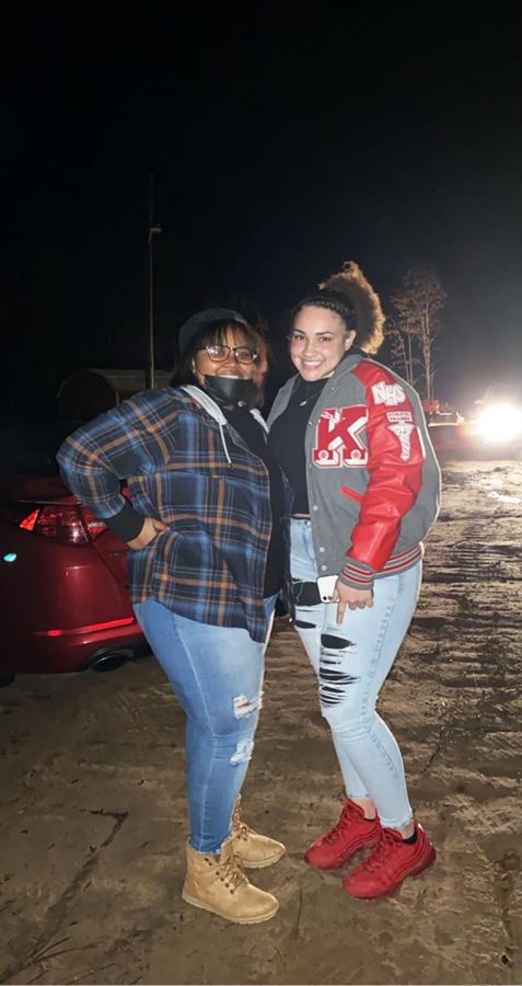 Senior Whitney Hunt and former student Skye Cotton smile for a picture during the bonfire.