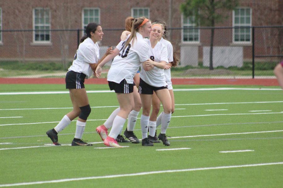 The soccer girls celebrate after scoring a point. 