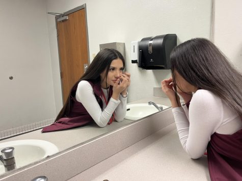 Junior Melanie Munos Martines picks at her skin in the mirror. Photo by Jayden Jones.