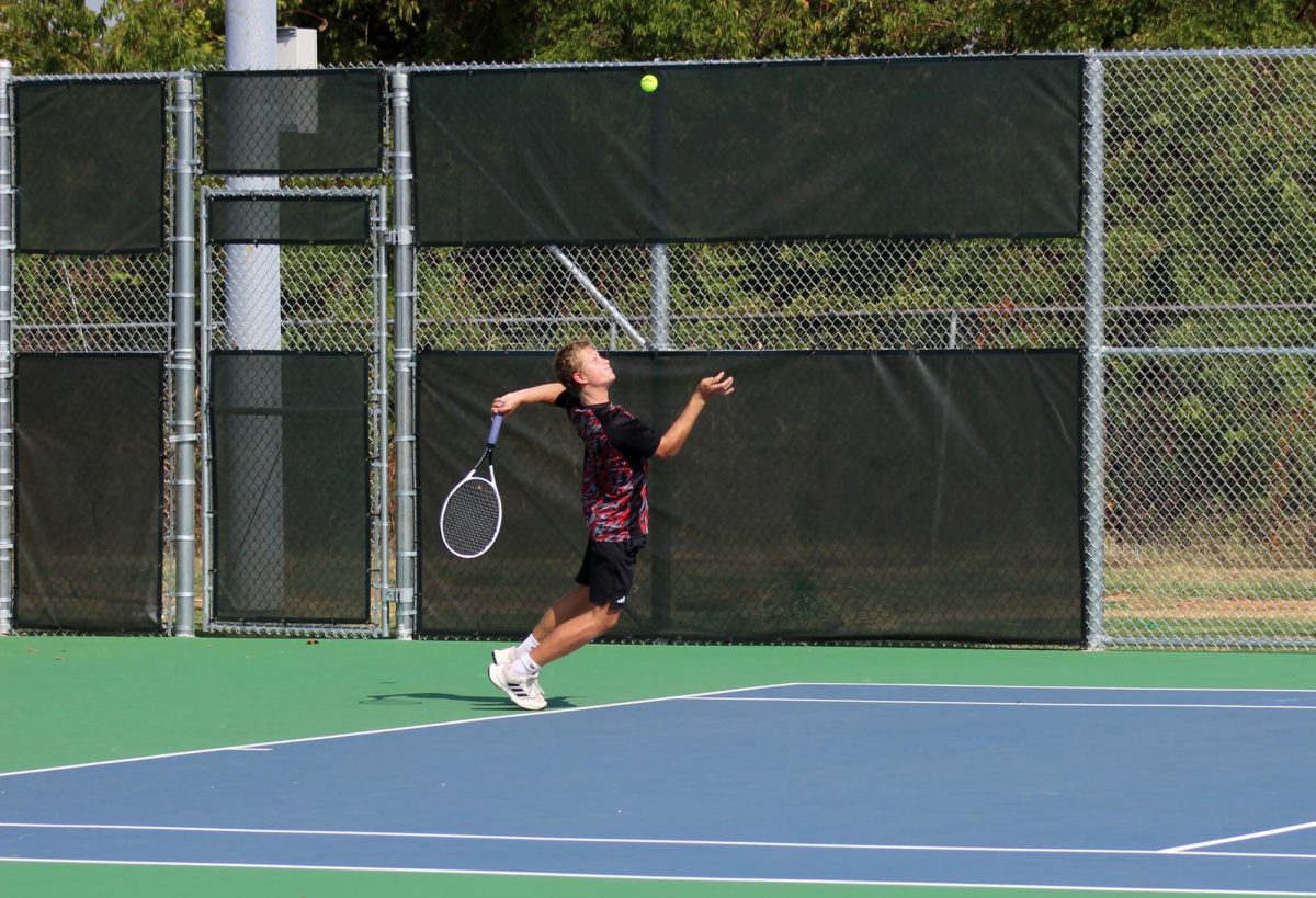 Junior J.T. Mercer jumping into a serve during his singles match.