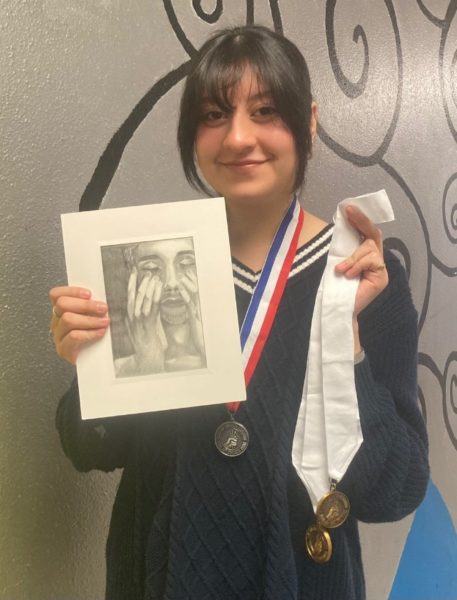 Junior Syghlas Morales with her medals and artwork from the VASE competition. Courtesy photo by Holly Harper.