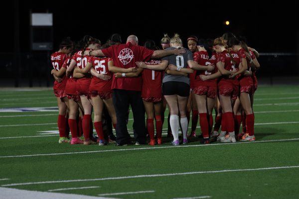The varsity Girls soccer take a moment to pray before their game against the Henderson Lions.