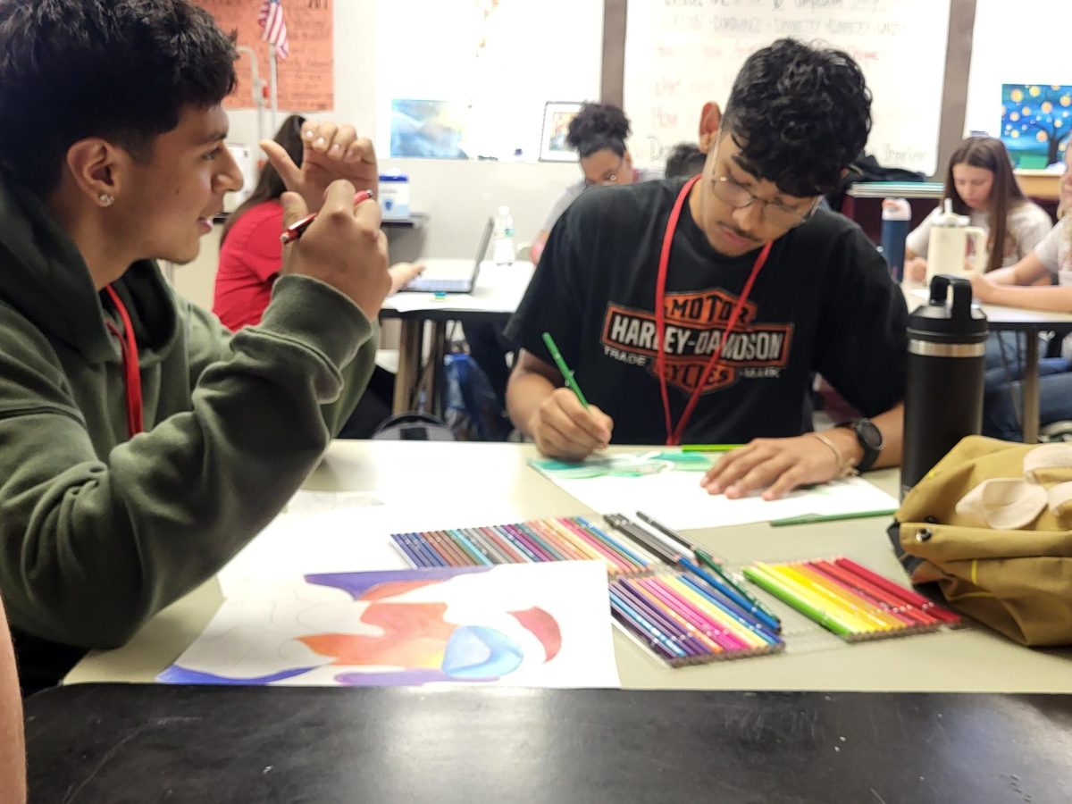 Seniors Luciano Brizuela and Kevin Aguilar work on their abstract art assignment.